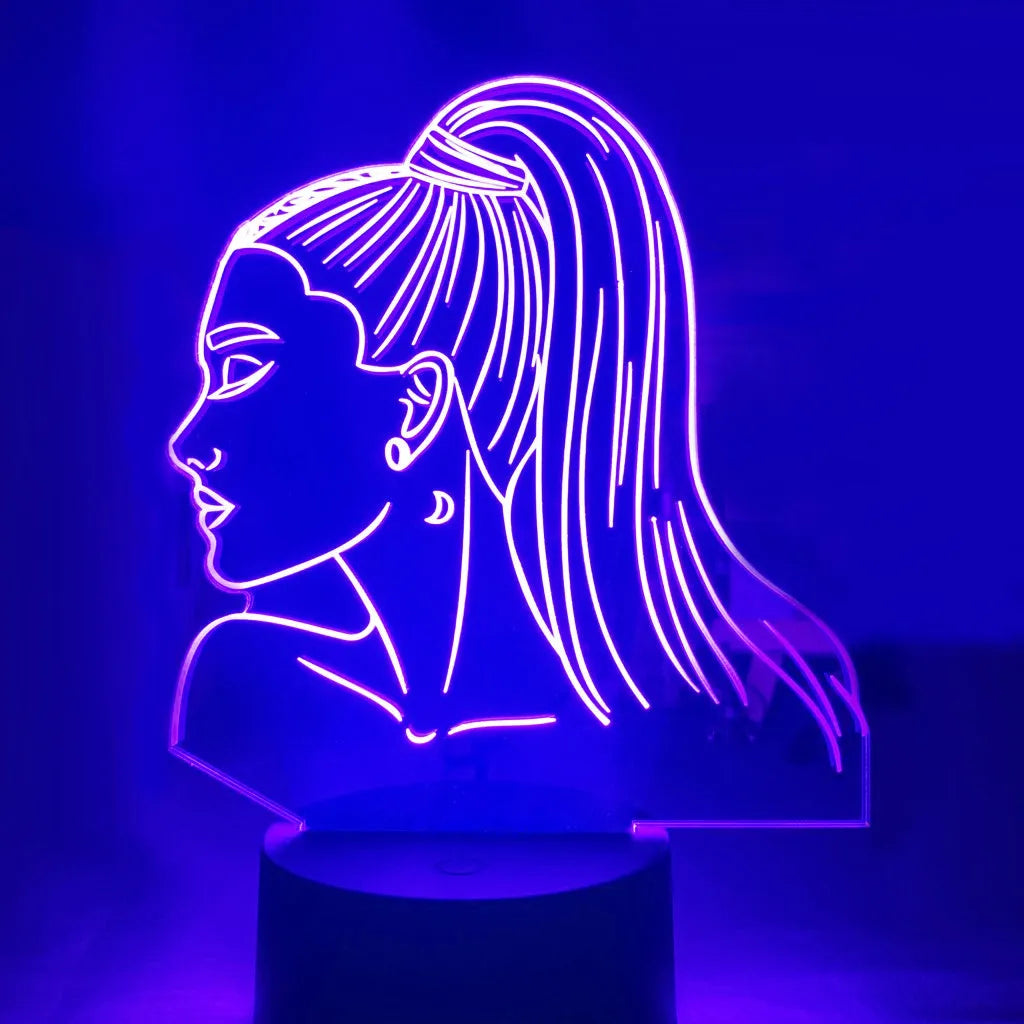Black based LED desk lamp with colourful acrylic shade and a small remote control on a wooden desk.