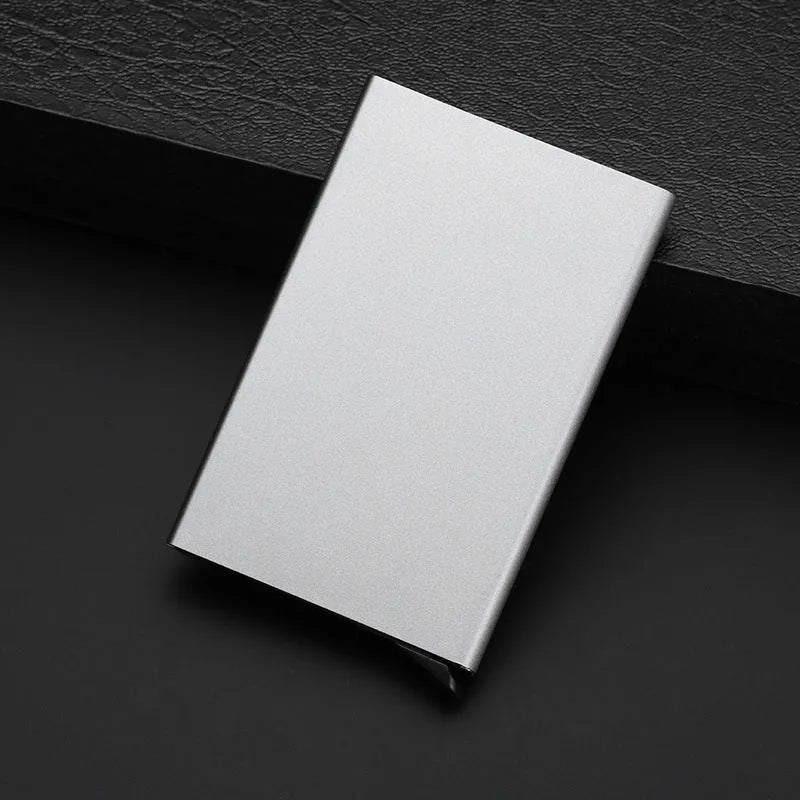 Aluminium alloy geometric business card holder in silver, 9.5 cm high, on a desk