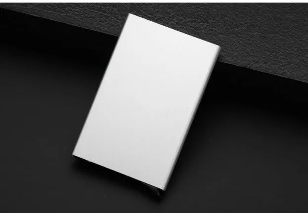 Aluminium alloy geometric business card holder in silver, 9.5 cm high, on a desk