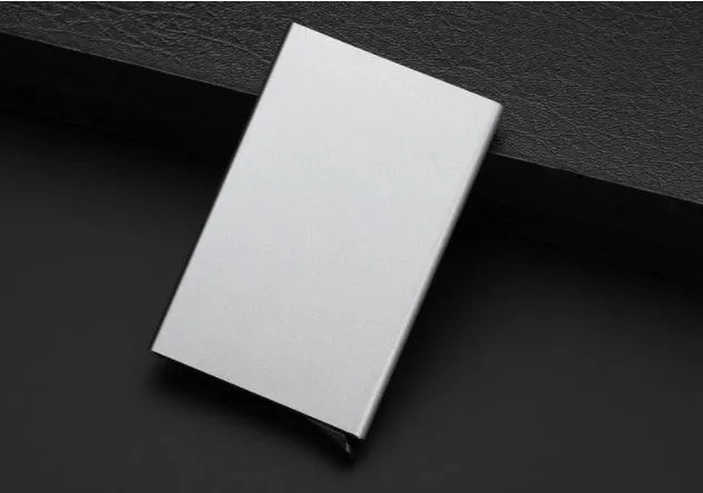 Aluminium alloy geometric business card holder in silver, 9.5 cm high, on a desk