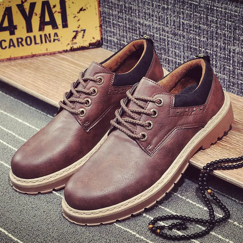 Men's black casual shoes with round toe, flat heel, and front lace-up design on a plain background.