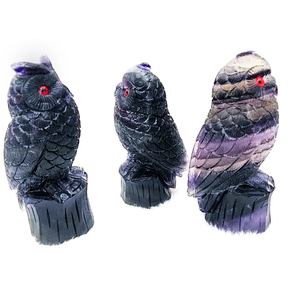 Purple fluorite hand-carved owl ornament on a neutral background, showing natural stone colour and carving detail.