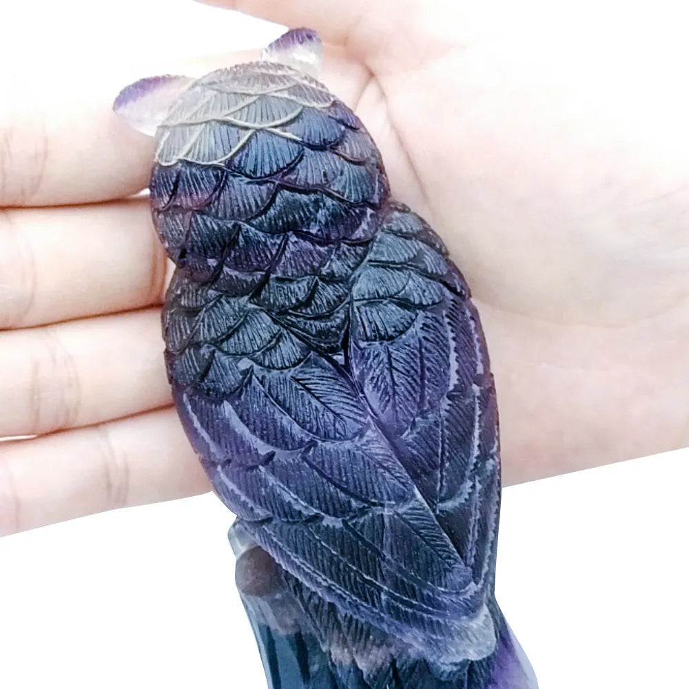 Purple fluorite hand-carved owl ornament on a neutral background, showing natural stone colour and carving detail.