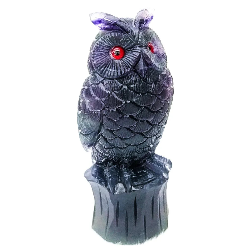 Purple fluorite hand-carved owl ornament on a neutral background, showing natural stone colour and carving detail.