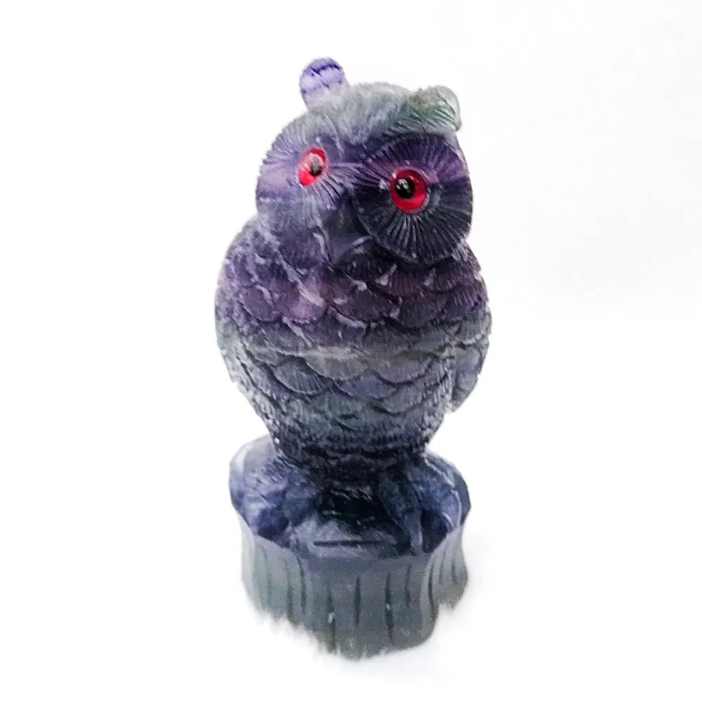 Purple fluorite hand-carved owl ornament on a neutral background, showing natural stone colour and carving detail.