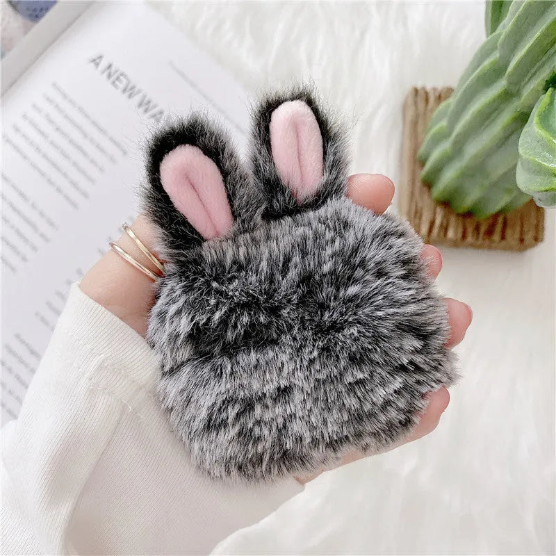 Soft pink silicone AirPod case with rabbit ears design on a grey background.