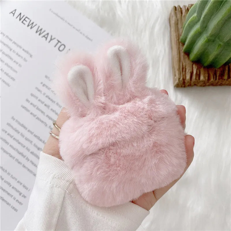 Soft pink silicone AirPod case with rabbit ears design on a grey background.