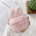 Soft pink silicone AirPod case with rabbit ears design on a grey background.