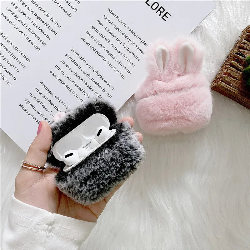Soft pink silicone AirPod case with rabbit ears design on a grey background.