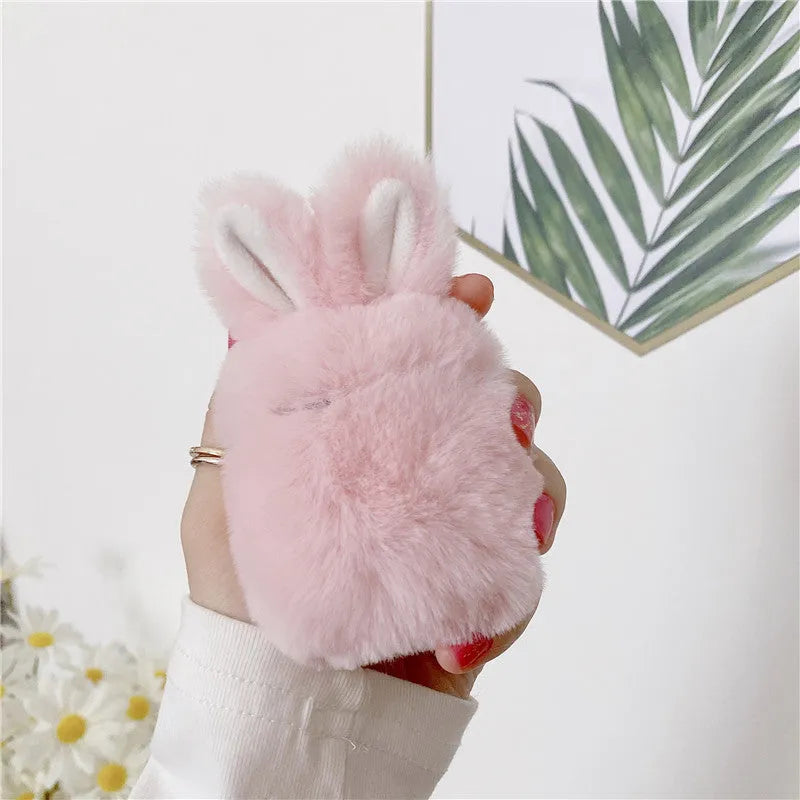 Soft pink silicone AirPod case with rabbit ears design on a grey background.