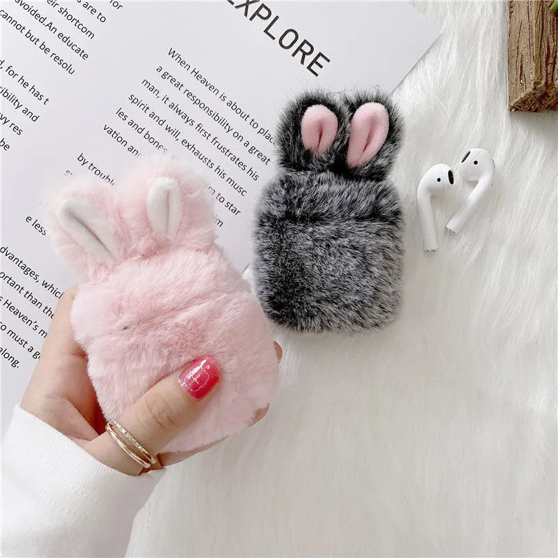 Soft pink silicone AirPod case with rabbit ears design on a grey background.