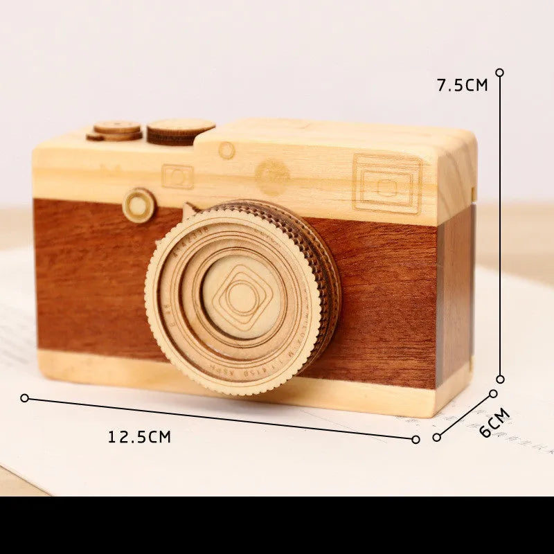 Wooden music box with a rotating camera design on a pine wood base.