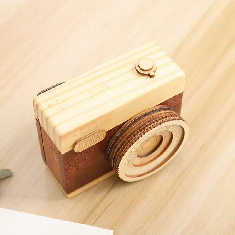 Wooden music box with a rotating camera design on a pine wood base.