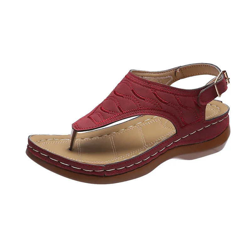 Women's red wedge heel sandals with an adjustable buckle strap on a white background