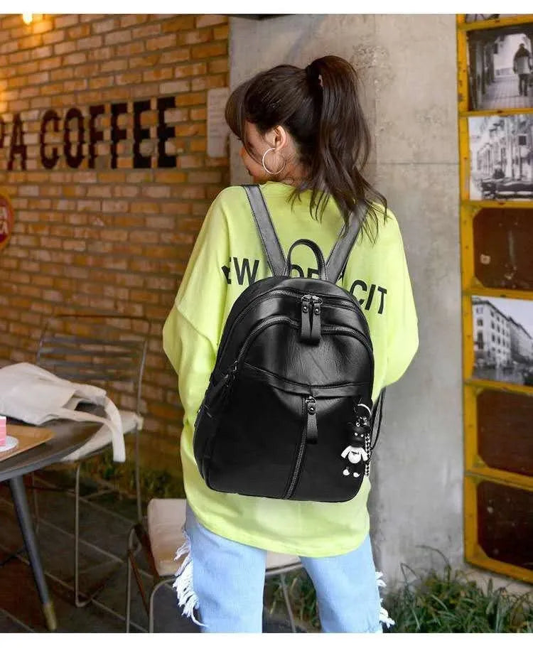 Black PU leather backpack with double straps showing internal ID bag compartment and zipper closure