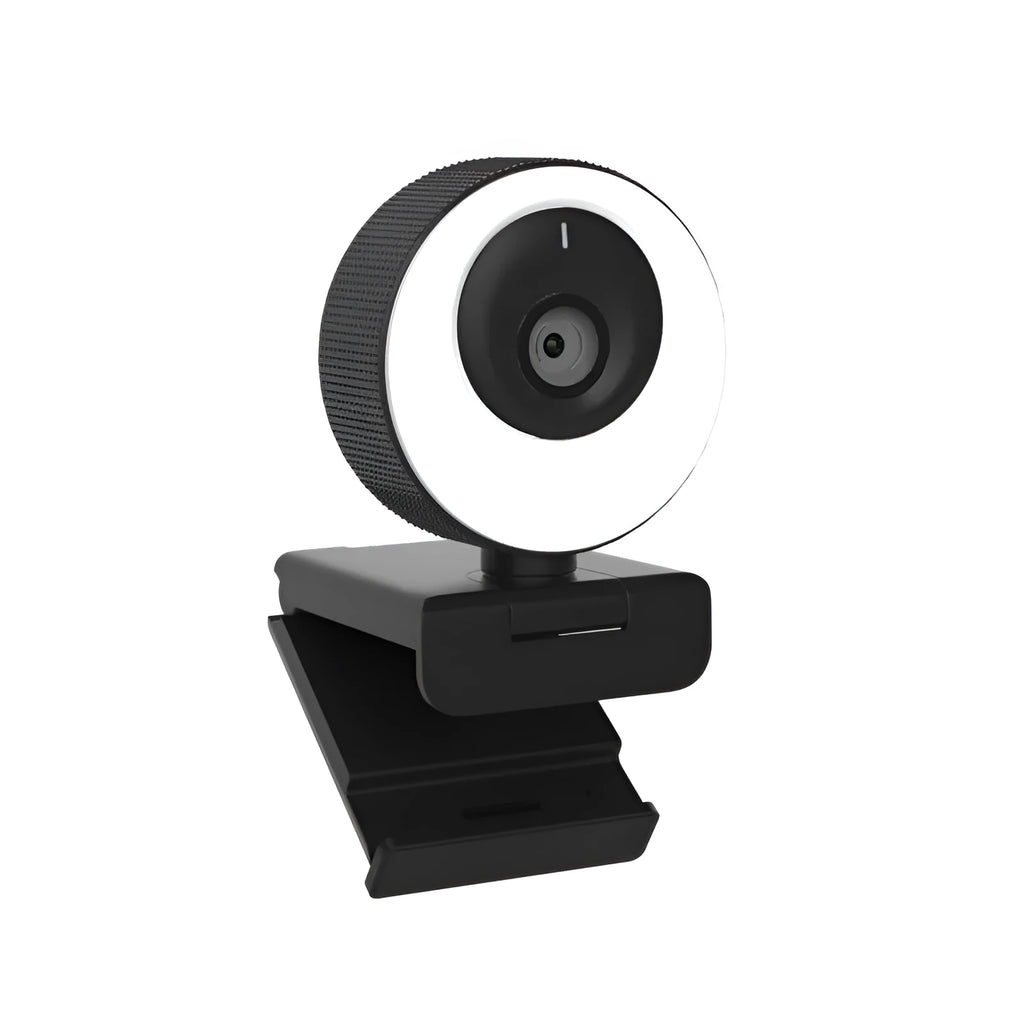 Black USB webcam with magnetic privacy cover on desktop next to computer monitor