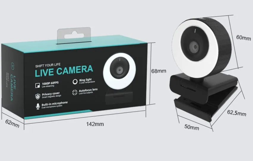 Black USB webcam with magnetic privacy cover on desktop next to computer monitor