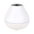 White round Bluetooth humidifier and essential oil aroma diffuser with night light on a table.