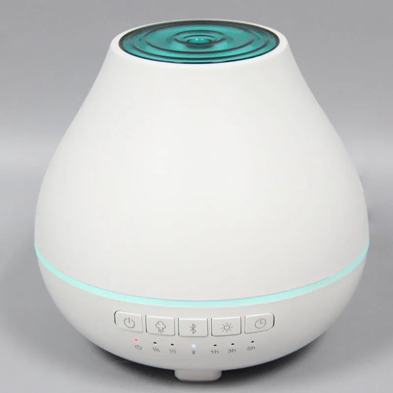 White round Bluetooth humidifier and essential oil aroma diffuser with night light on a table.