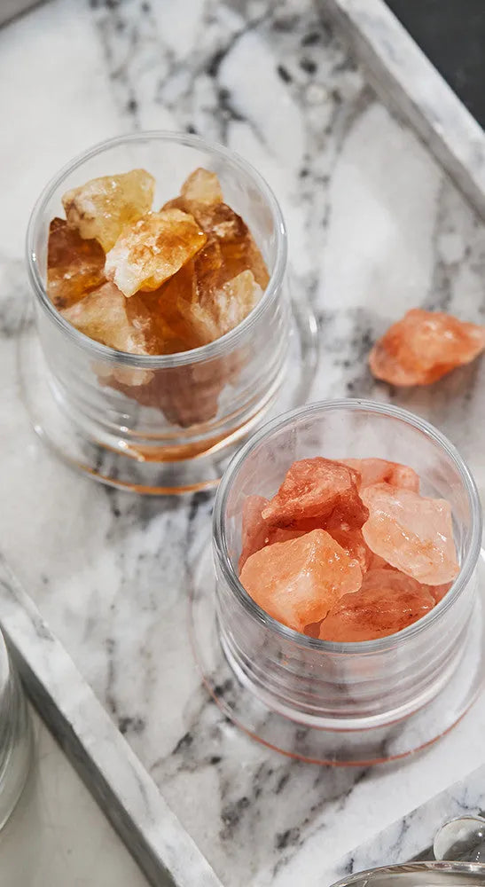 Crystal diffuser stone in pink with sesame oil bottle on a wooden surface for fire-free aromatherapy