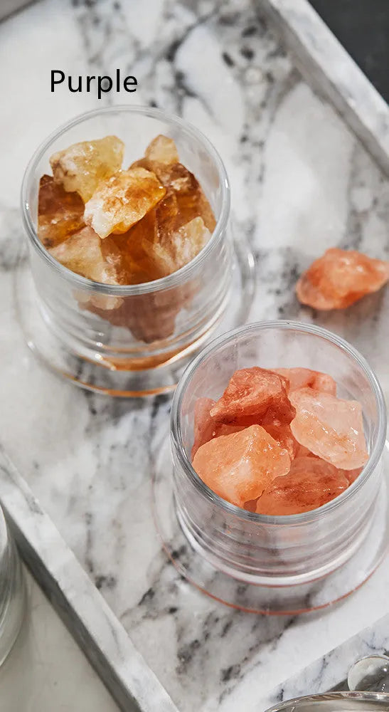 Crystal diffuser stone in pink with sesame oil bottle on a wooden surface for fire-free aromatherapy