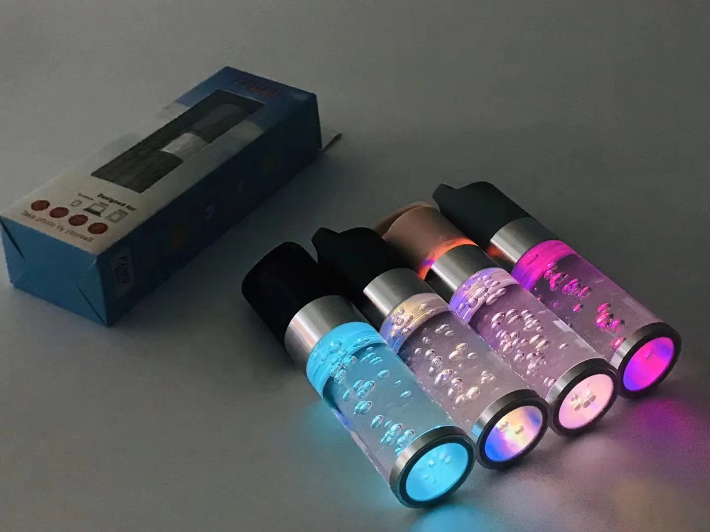 Pink cartoon-style portable Bluetooth speaker with colourful crystal lights on a desk.