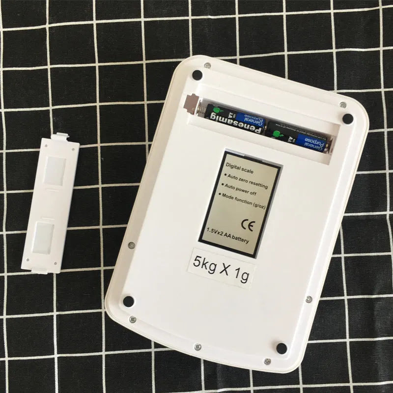 Electronic kitchen scale with digital display showing weight measurement, powered by AA batteries