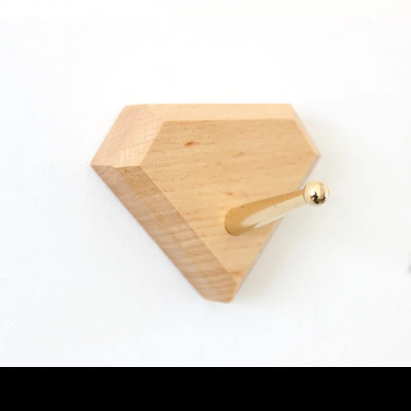 Solid beech wood adhesive wall hook with brass fitting in five shapes: capsule, diamond, oval, round, square.