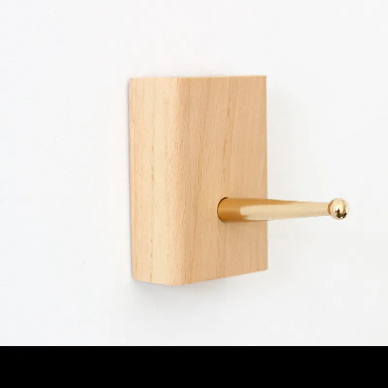 Solid beech wood adhesive wall hook with brass fitting in five shapes: capsule, diamond, oval, round, square.