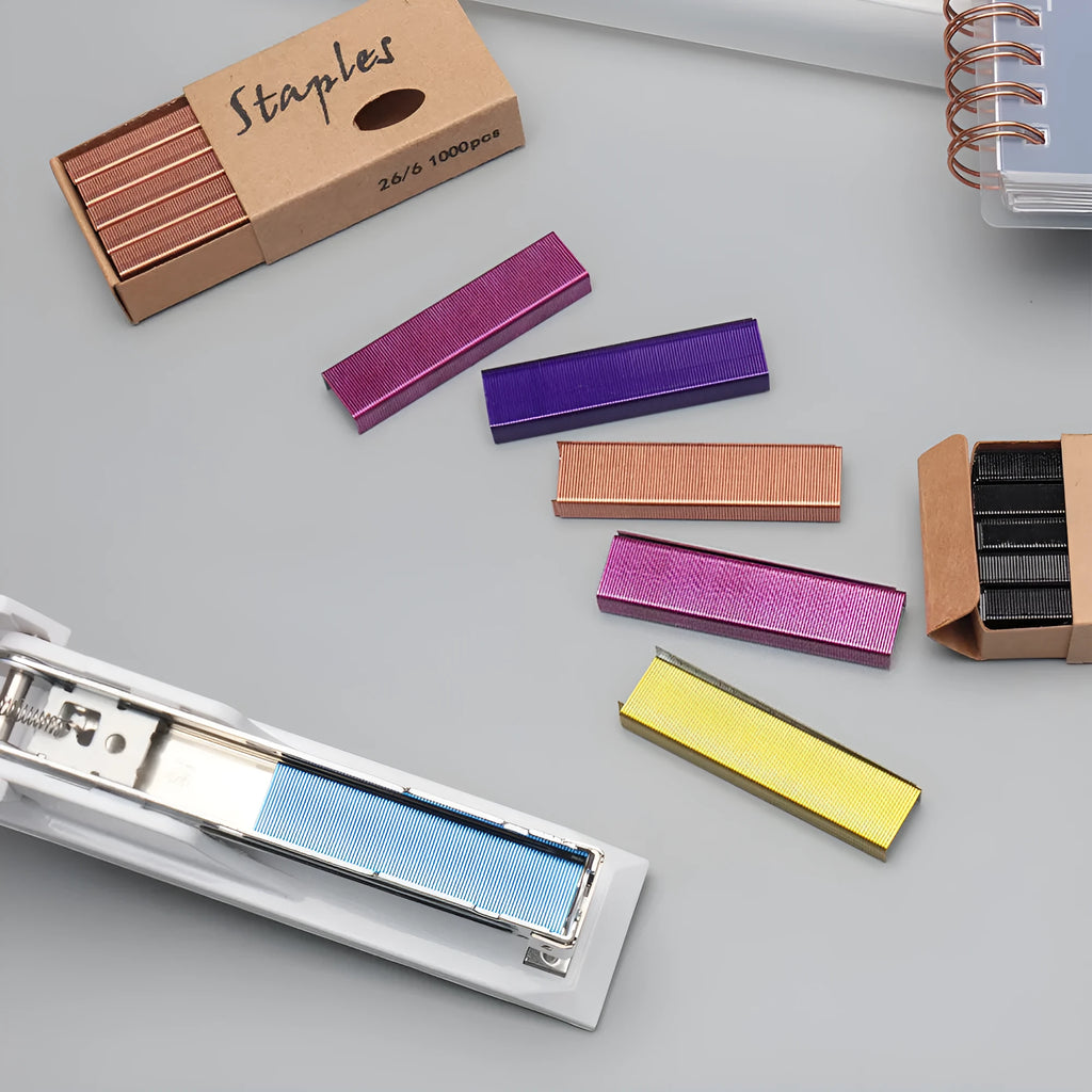 Box of 1000 metal office staples showing black, purple, rose gold, and rose red colour options.