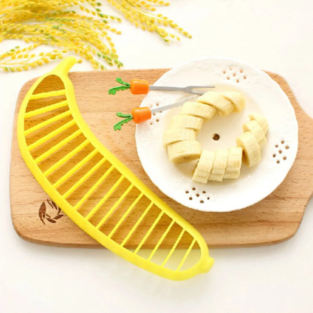 Yellow banana cutter slicer made from food-grade PP plastic, 25 x 7 x 1.4 cm, on a light background