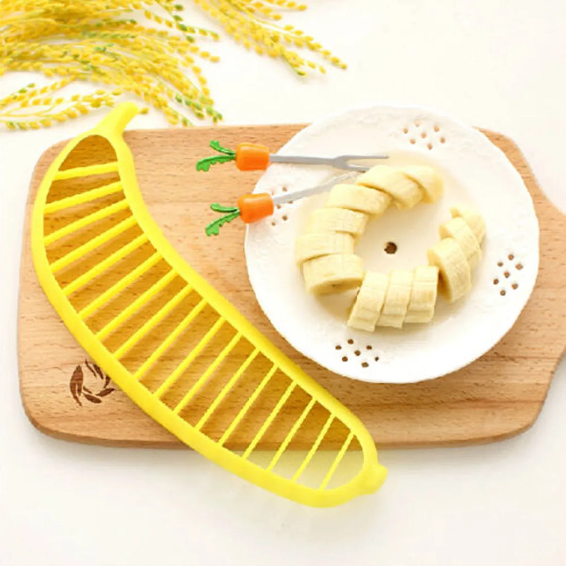 Yellow banana cutter slicer made from food-grade PP plastic, 25 x 7 x 1.4 cm, on a light background