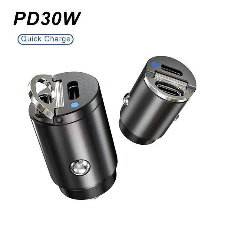 Black mini 30W dual USB car charger with zinc alloy housing next to a car cigarette lighter socket.
