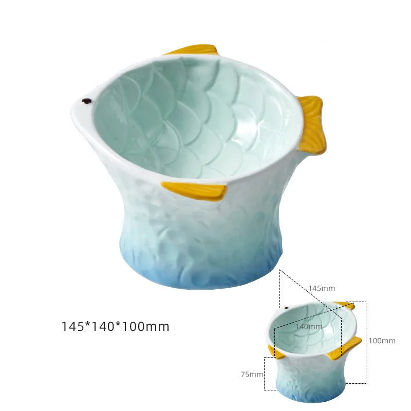 Set of four blue fish-shaped ceramic cat bowls with a tilted angle on a flat surface.