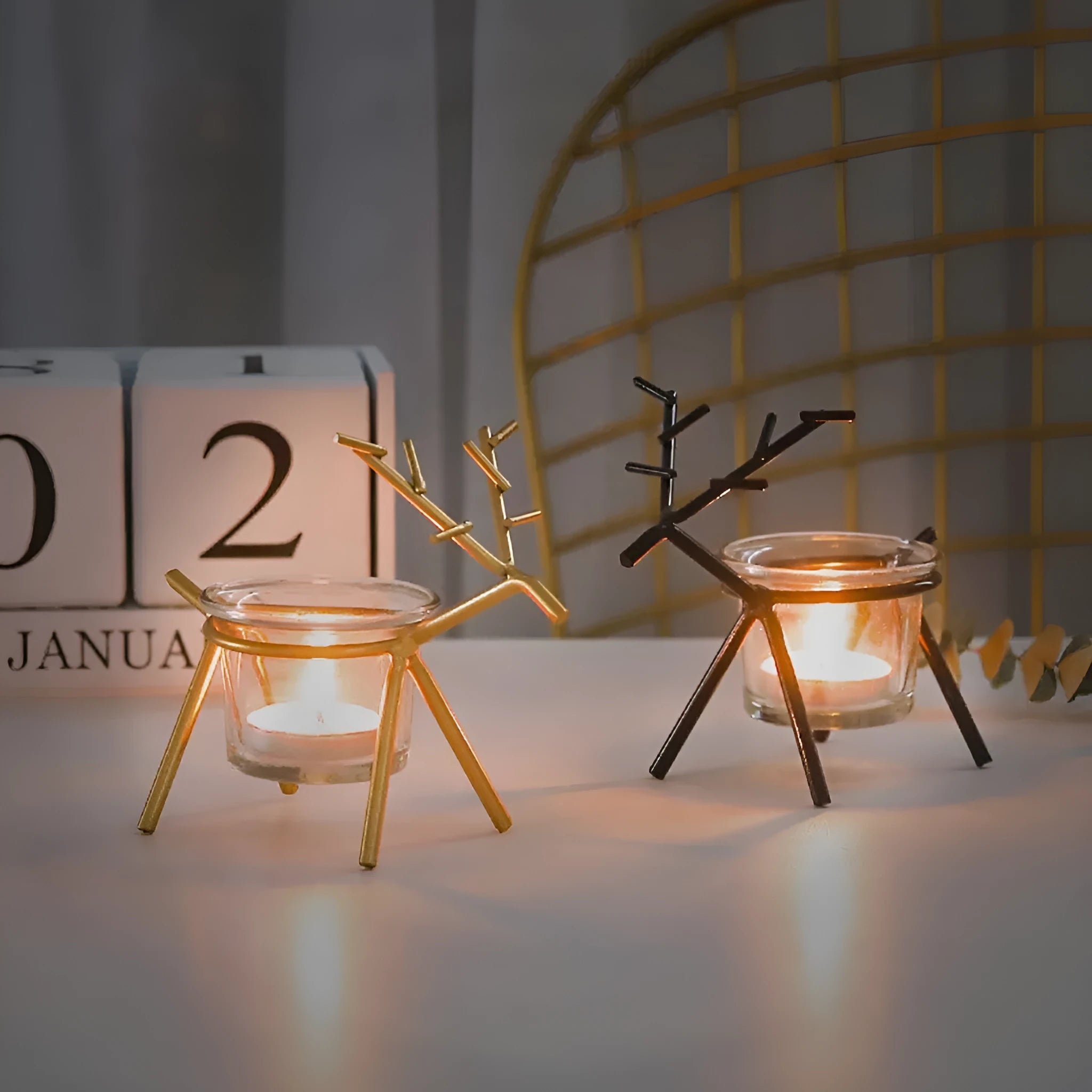 Wrought iron fawn-shaped candle holder with glass cup in gold electroplated finish