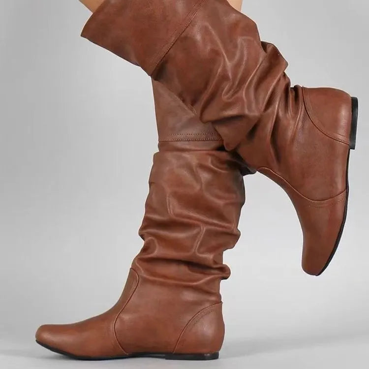 Women's flat heel black slip-on boots with round toe and high cylinder shaft.