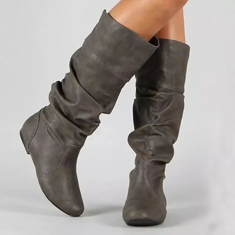 Women's flat heel black slip-on boots with round toe and high cylinder shaft.