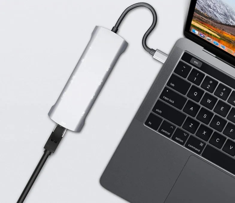 Grey aluminium USB-C docking station showing HDMI, VGA, USB 3.0, PD charging, and card reader ports.