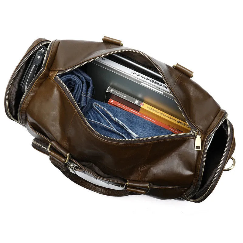 Coffee first layer cowhide leather travel bag with soft handle and zip closure on a plain background
