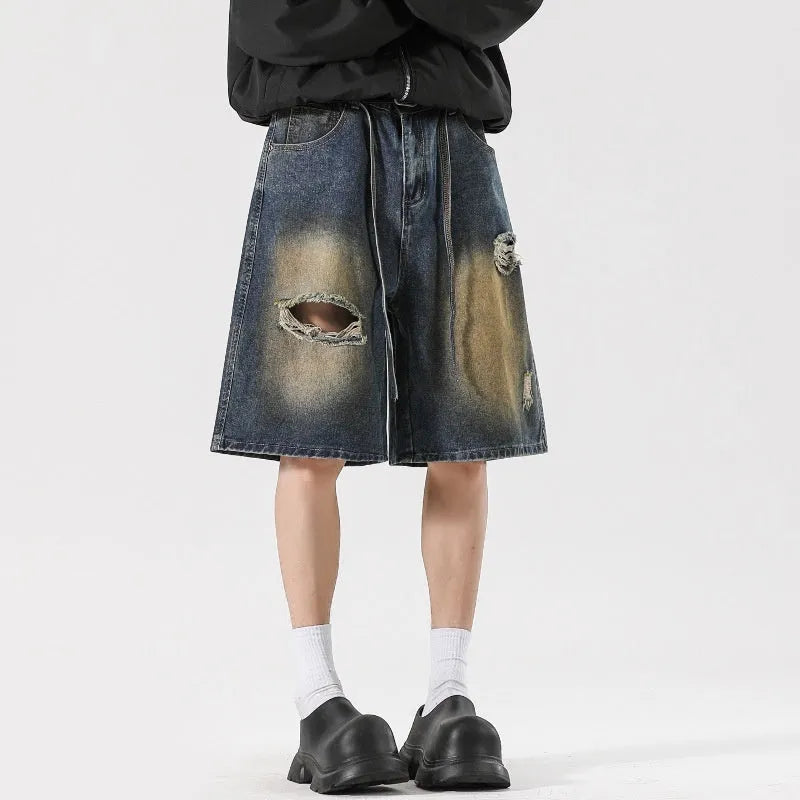 Men's retro blue loose-fit ripped jeans made from cotton denim, shown in a street style.