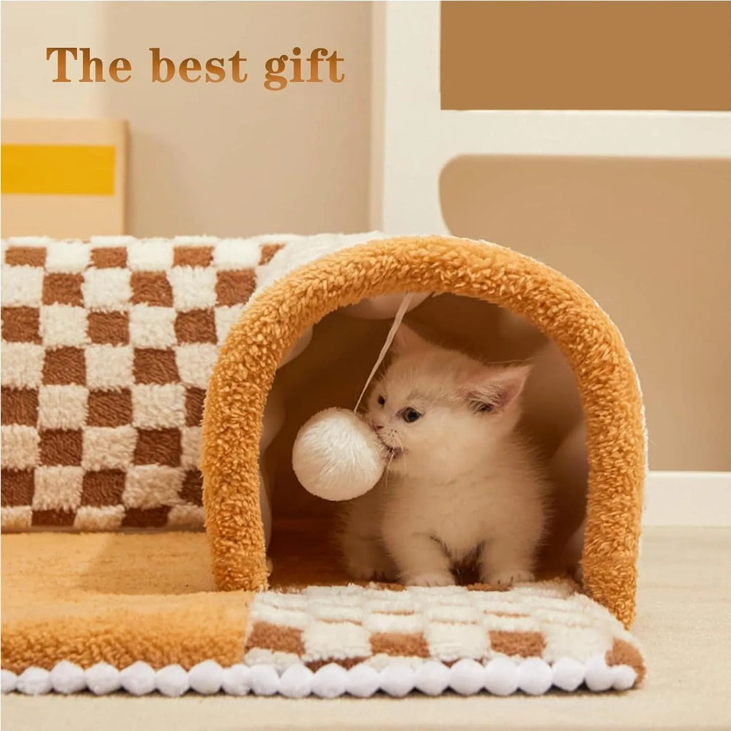 Brown plush plaid cat tunnel bed with a non-slip base on a wooden floor.