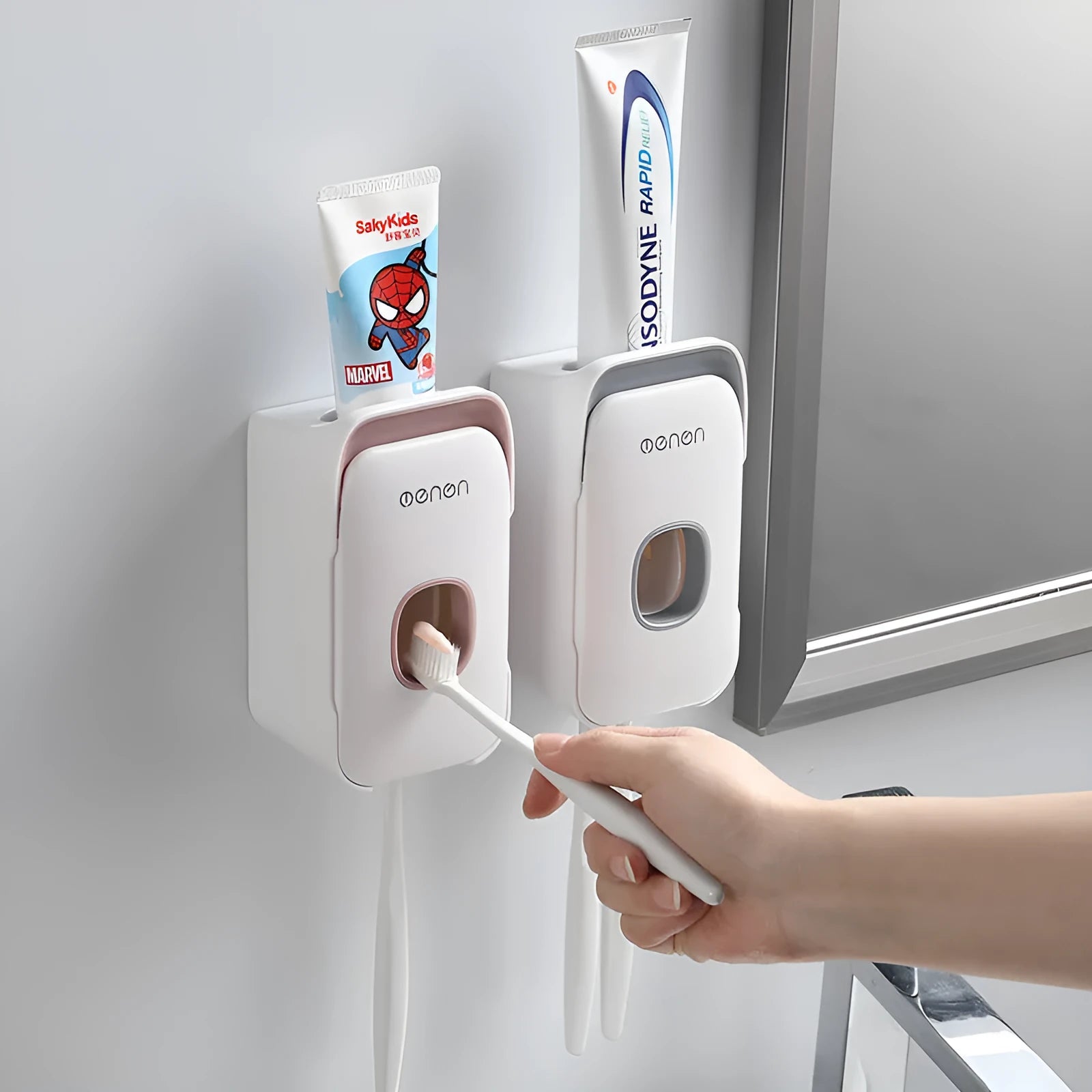 Blue automatic toothpaste dispenser mounted on a bathroom wall with a transparent window showing paste inside.