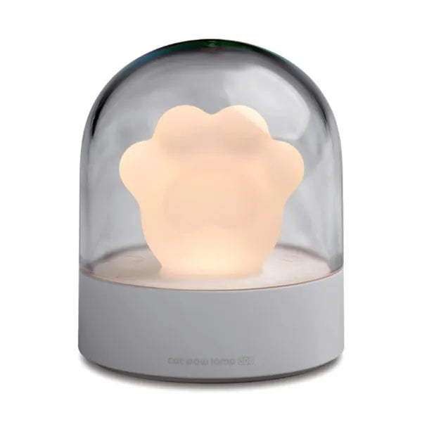 Grey and pink cat paw shaped USB night light with rotating lighting and music box features on desktop