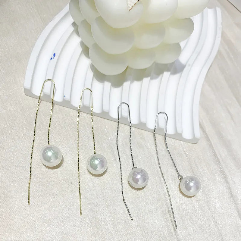 Fashionable long tassel pearl ear line drop earrings in gold finish on a white background