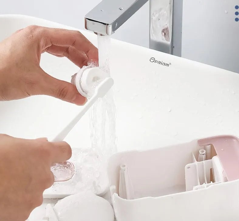 Blue automatic toothpaste dispenser mounted on a bathroom wall with a transparent window showing paste inside.