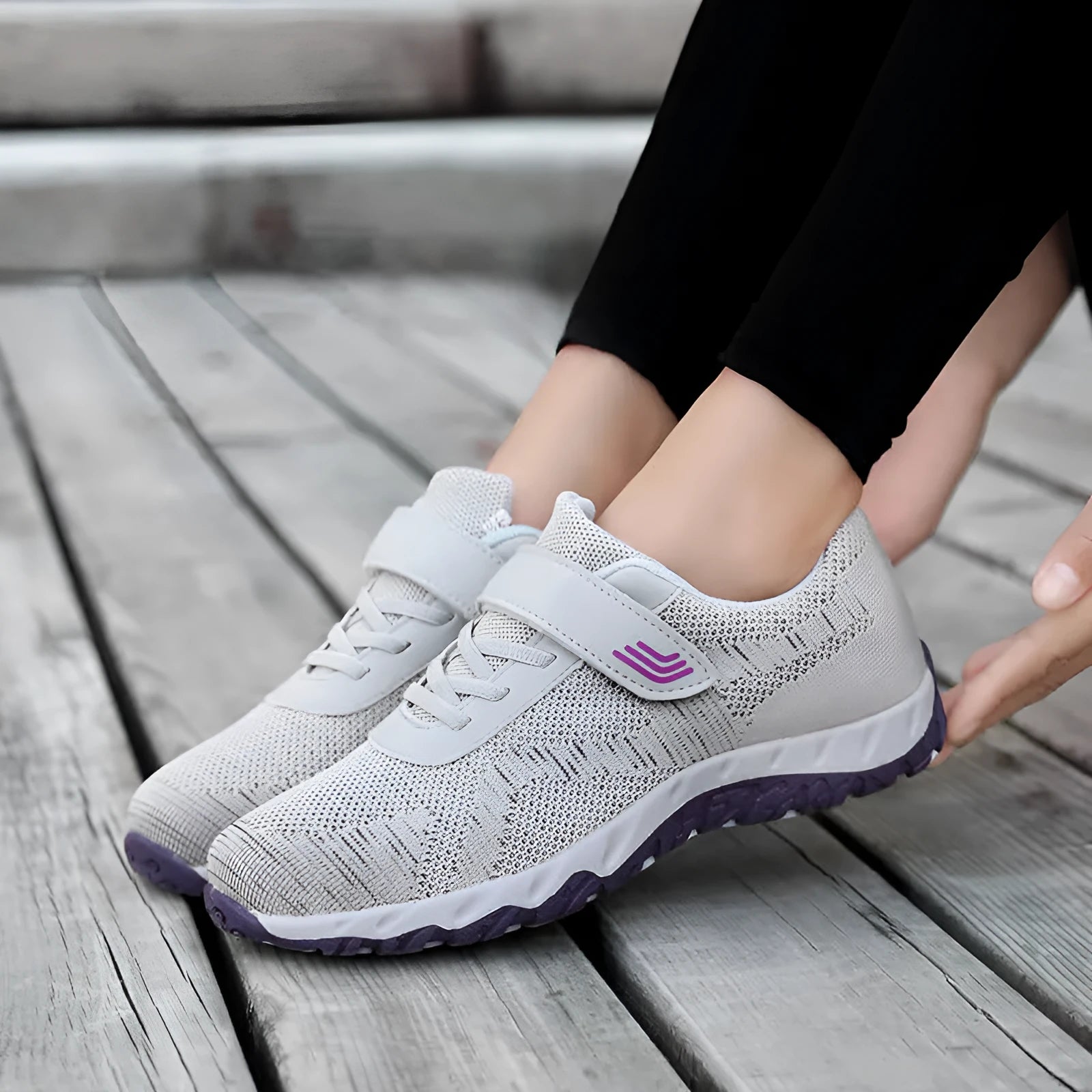 Women's grey purple wedge shoe with Velcro strap and mesh upper on a solid colour background.