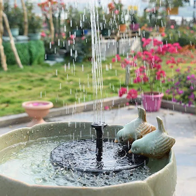 Solar floating fountain with round black panel and four spray nozzles on water surface