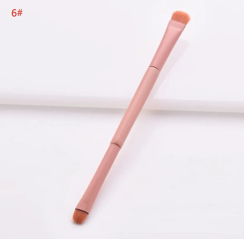Ten cosmetic makeup brushes with wooden handles arranged showing various brush head shapes and sizes