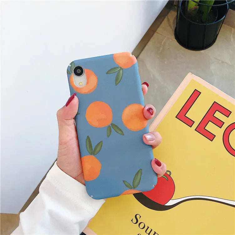 Orange retro plastic iPhone case with water and blue background design on a table.
