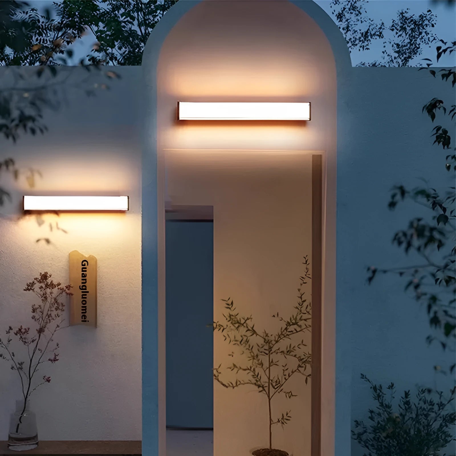 Modern outdoor wall lamp mounted on stone wall, showing clean lines and illuminated light source.